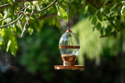 Hazel fuglemater er en nydelig fuglemater laget med kobber patina og elegant håndblåst glass.