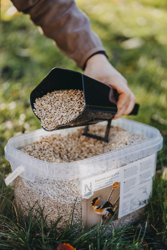 Svart forskuffe i PP brukt til å helle fuglemat utendørs