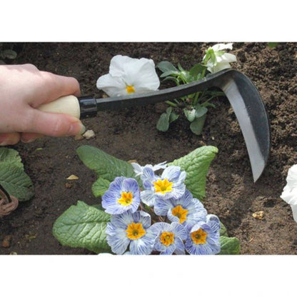 Venstrehendt ugressjern i bruk til presis luking mellom planter i hagebed